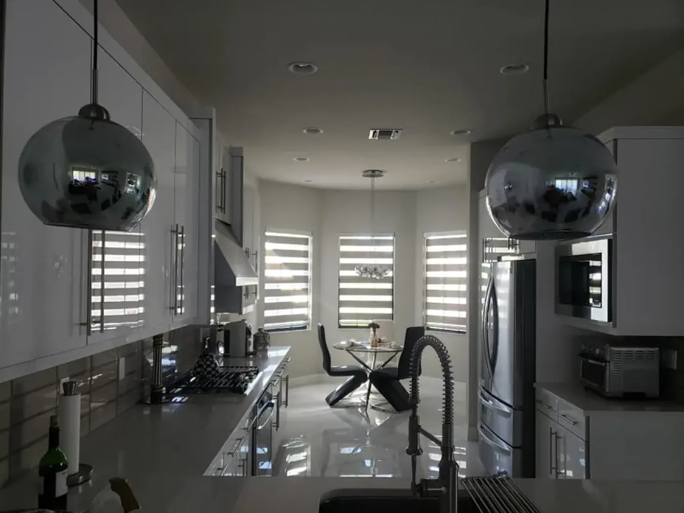 Kitchen with zebra roller shades on three windows